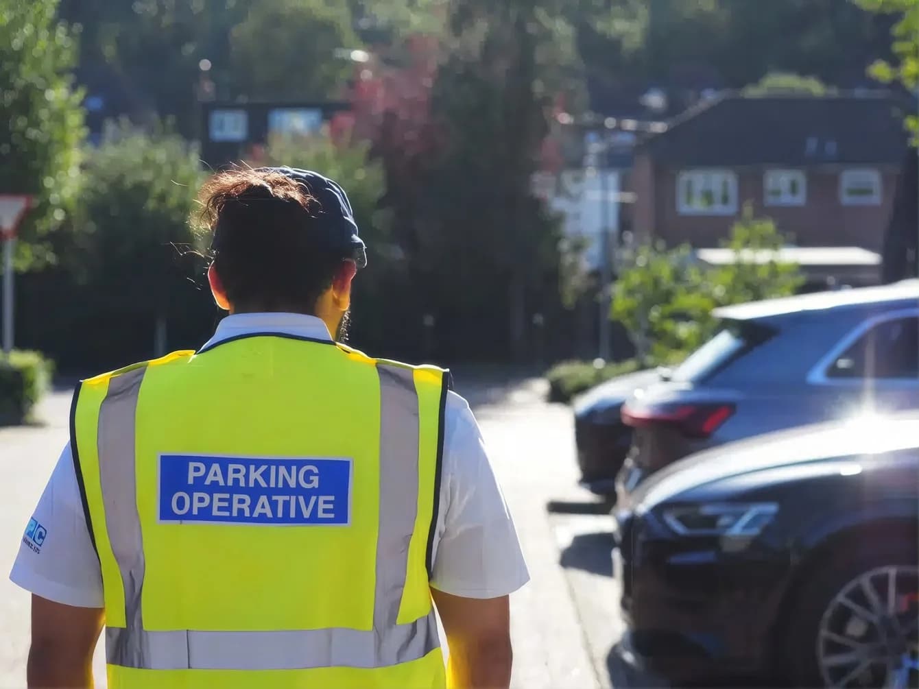 Parking operative in a high-visibility vest patrolling a street
